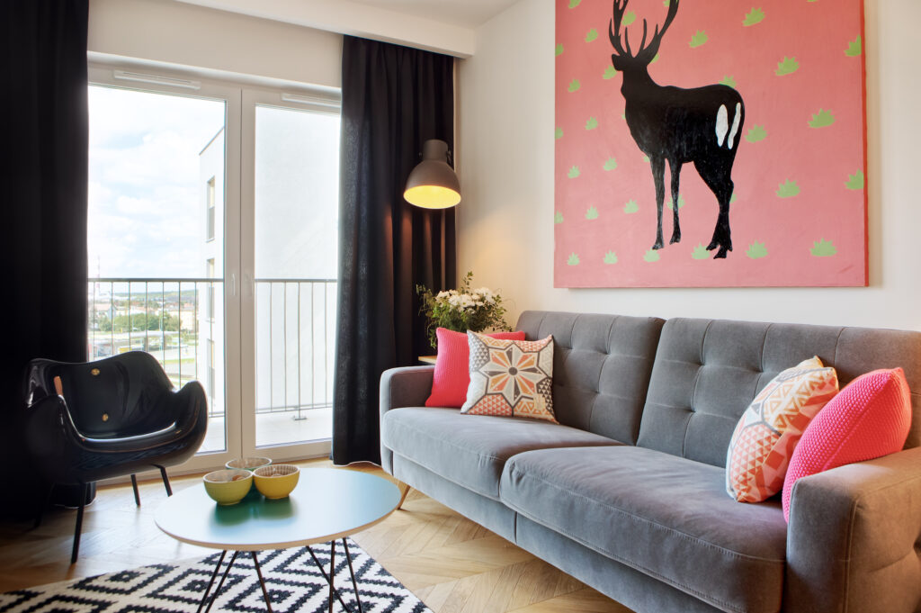 Nowoczesny salon z designerskim krzesłem, stolikiem kawowym sofa z kolorowymi akcentami.